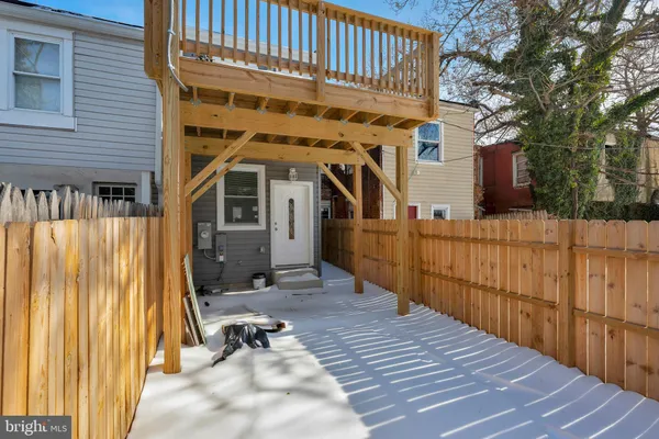 a view of a blue house with a yard and parking space