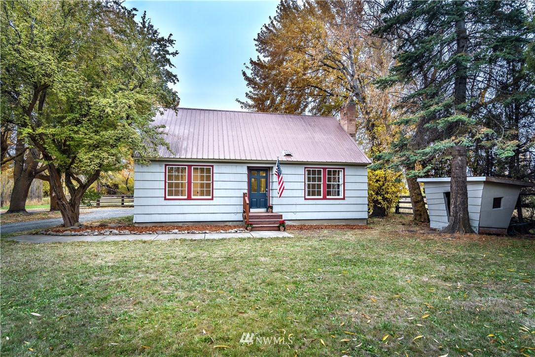 a front view of a house with a garden and trees