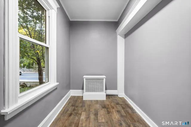 a view of a room with wooden floor and a window