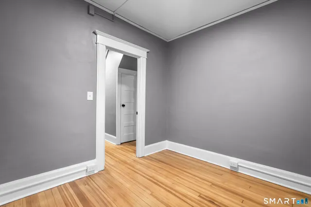 a view of empty room with wooden floor
