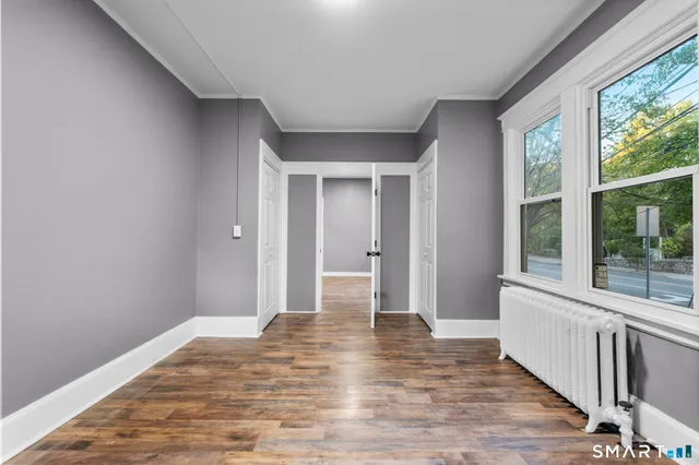 a view of a room with wooden floor and a window