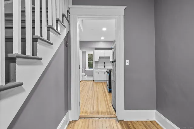 a view of a hallway with wooden floor and staircase