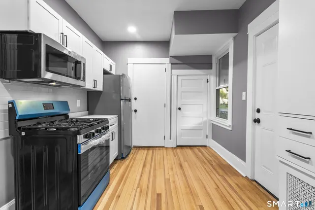 a kitchen with stainless steel appliances a stove a microwave and cabinets