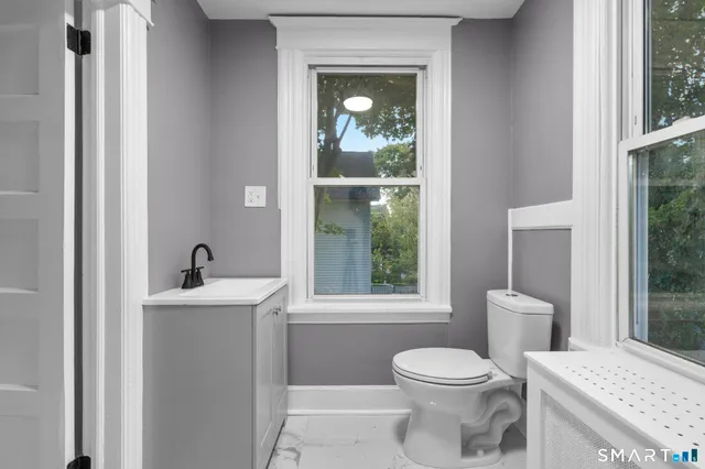 a bathroom with a toilet a sink and mirror