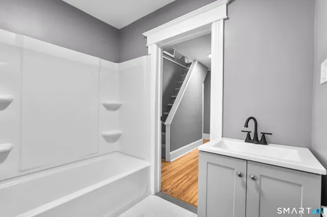 a bathroom with a bathtub sink and mirror