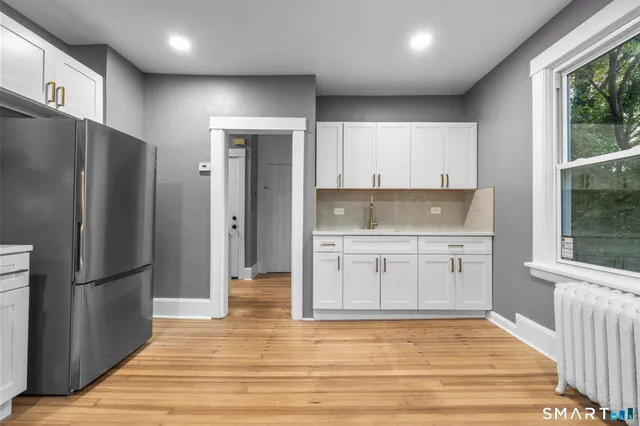 a kitchen with stainless steel appliances granite countertop a refrigerator and a stove