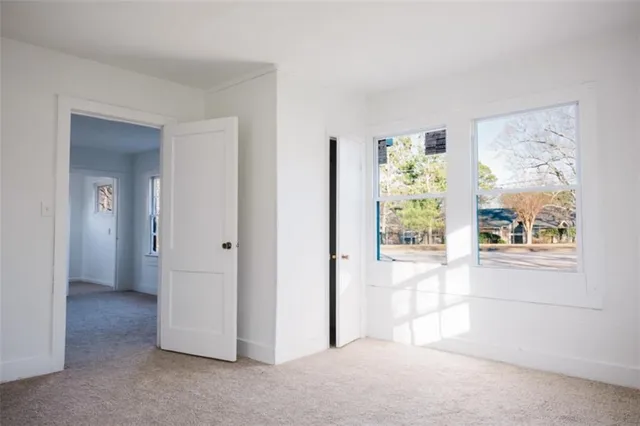 a view of a white house with a yard covered with snow