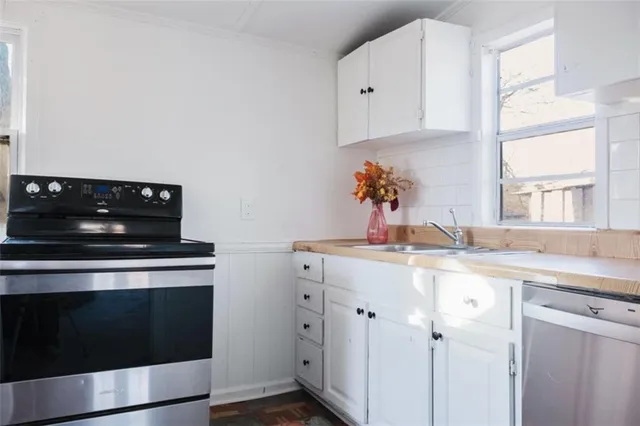 a kitchen with a stove and white cabinets