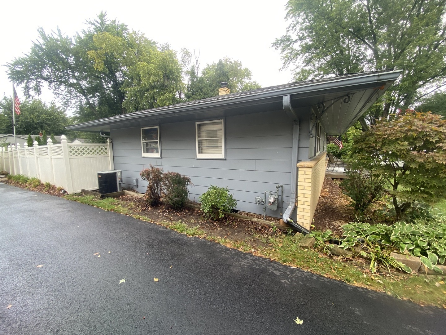 4714 Mohawk Road Rockford, IL 61107 - Photo 2 of 3 a backyard of a house with table and chairs under an umbrella