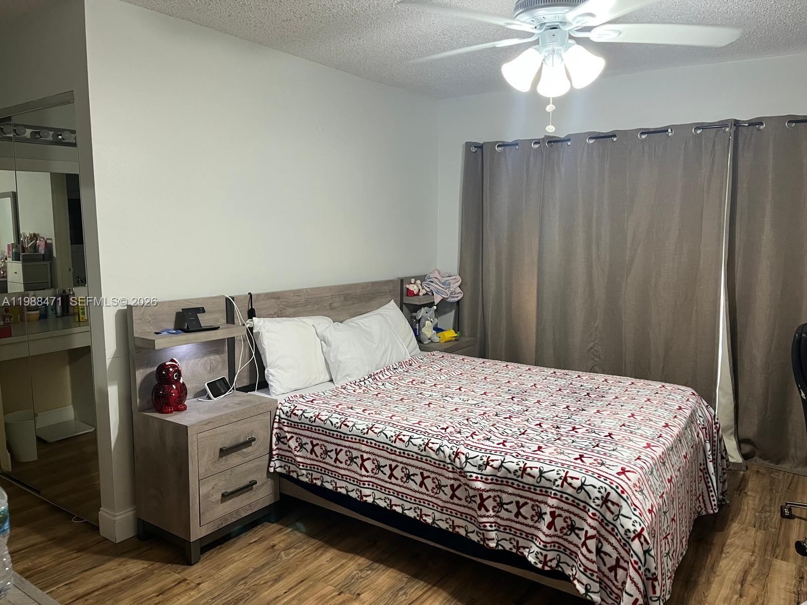 301 North Pine Island Road, Unit 156 Plantation, FL 33324 - Photo 8 of 16 a bedroom with a bed and wooden floor