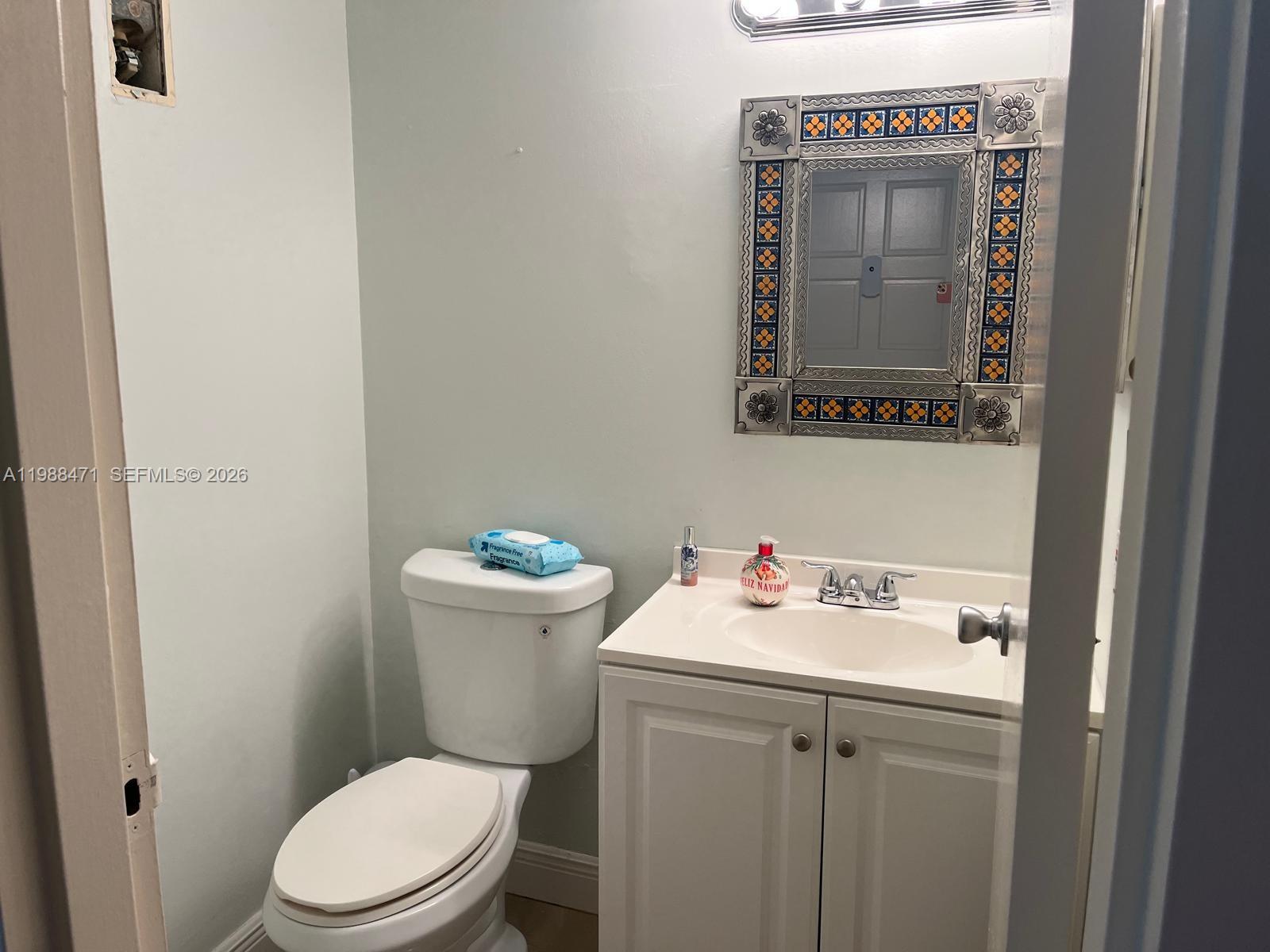 301 North Pine Island Road, Unit 156 Plantation, FL 33324 - Photo 10 of 16 a bathroom with a toilet sink vanity and mirror