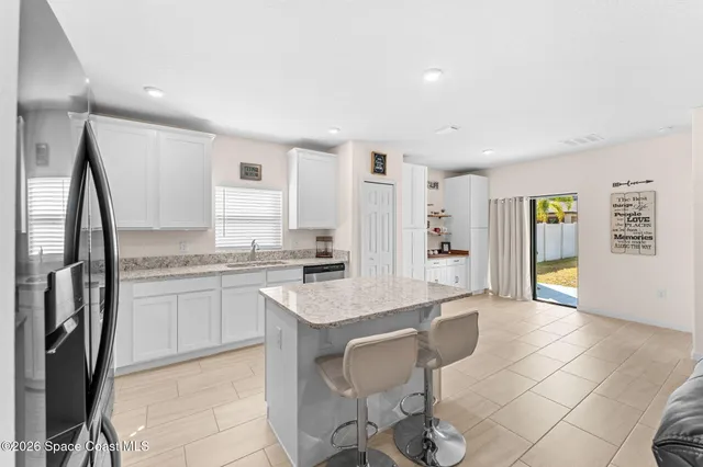 a kitchen with stainless steel appliances granite countertop a sink and a refrigerator