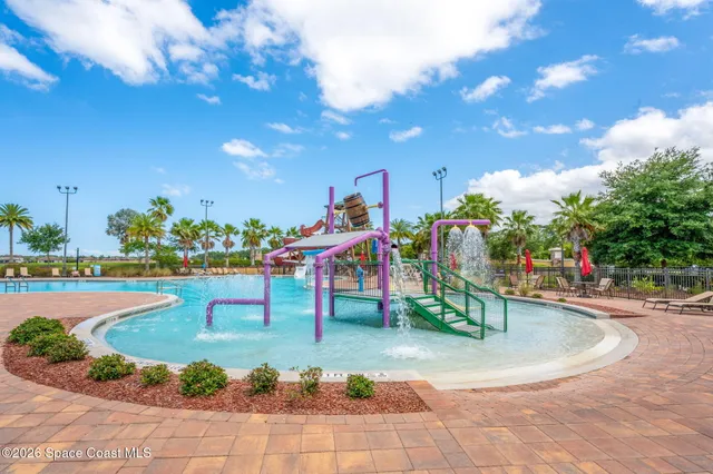 a view of a swimming pool with a lawn chairs under an umbrella