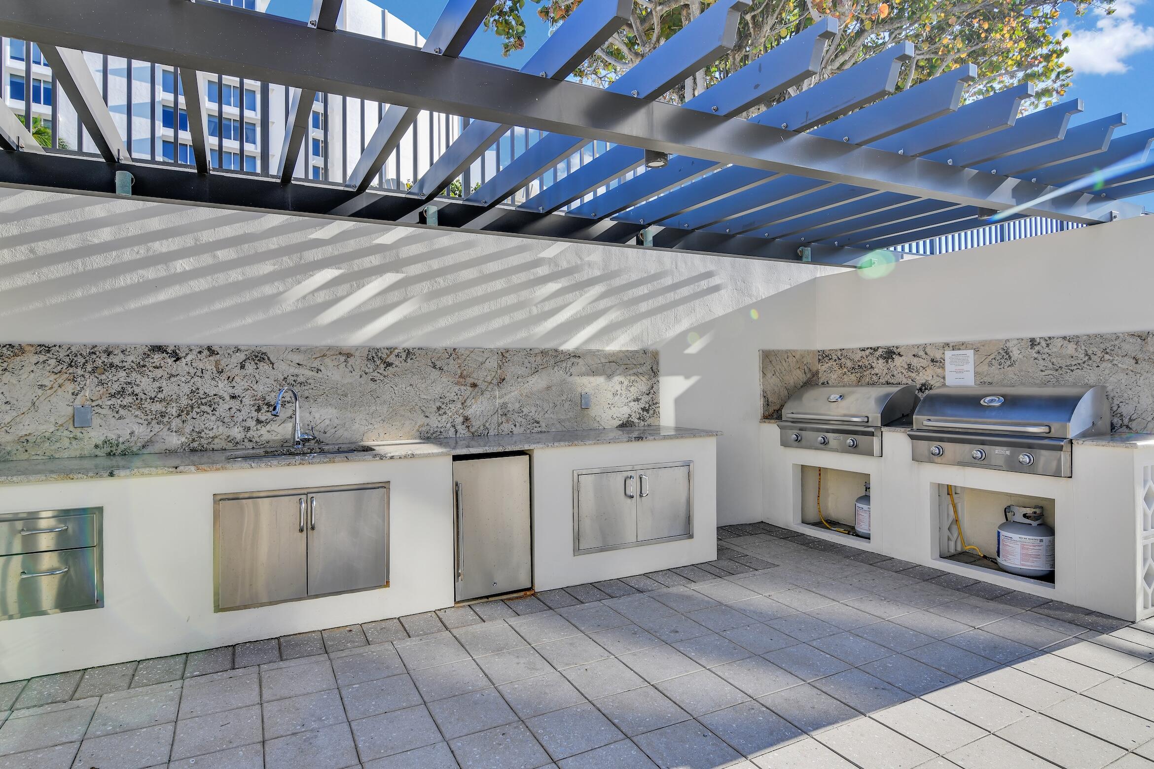 600 South Ocean Boulevard, Unit 802 Boca Raton, FL 33432 - Photo 12 of 27 a kitchen with granite countertop a stove cabinets and a sink