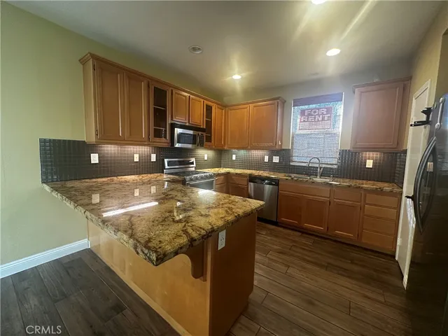 a kitchen with stainless steel appliances granite countertop a sink a stove a microwave a sink and cabinets