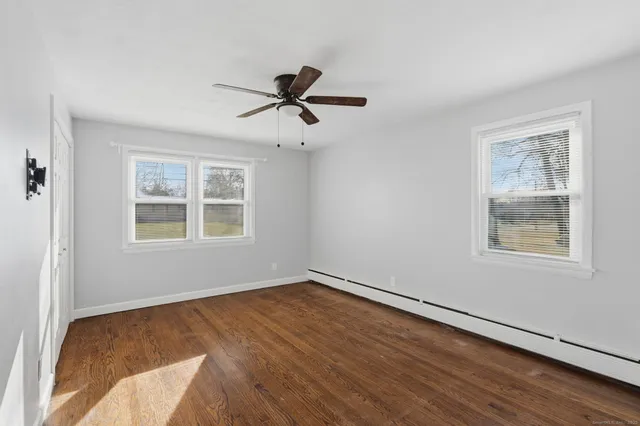 a view of a room with wooden floor and windows