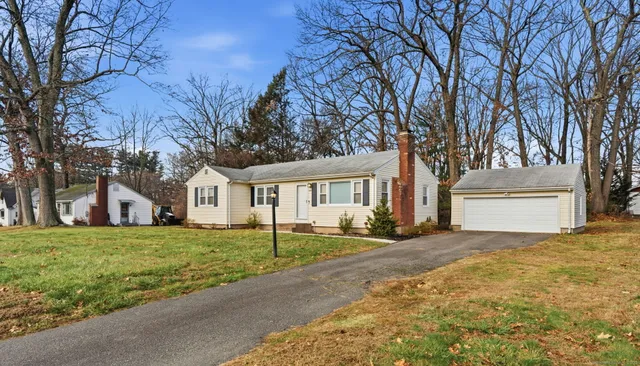 a front view of a house with a yard and trees