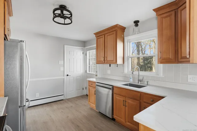 a kitchen with stainless steel appliances granite countertop a sink a stove and a refrigerator