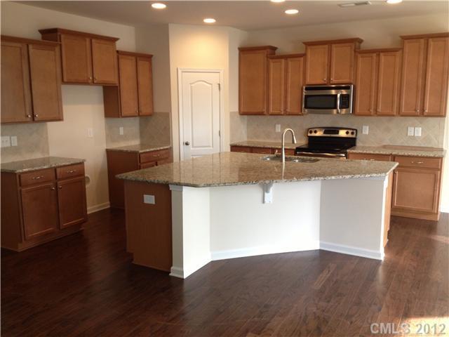 4017 Perth Road, Unit 400 Indian Land, SC 29707 - Photo 2 of 11 a kitchen with stainless steel appliances granite countertop a stove a sink a refrigerator a microwave oven with cabinets and wooden floor