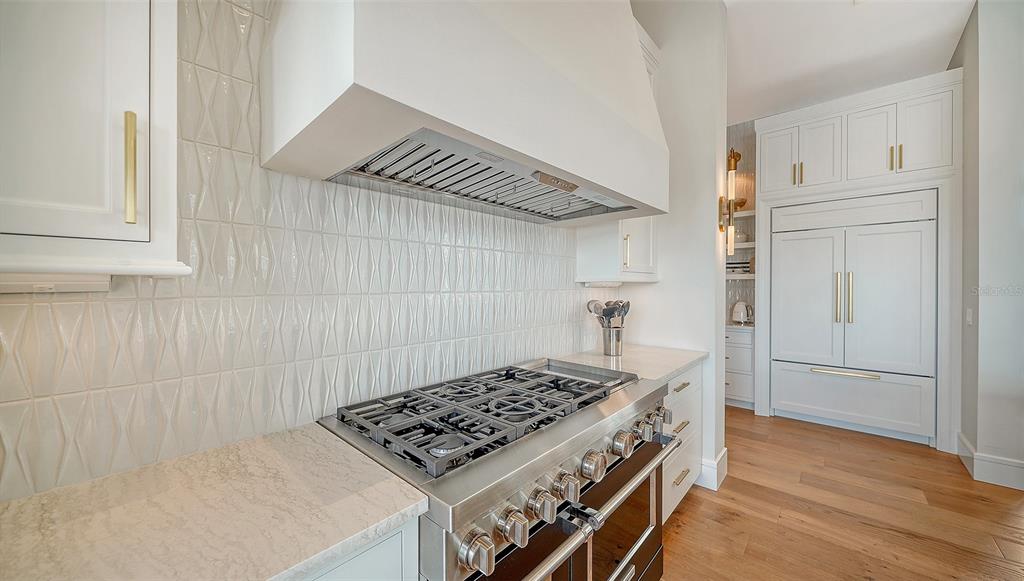 681 Old Compass Road Longboat Key, FL 34228 - Photo 16 of 67 a kitchen with white cabinets and stove