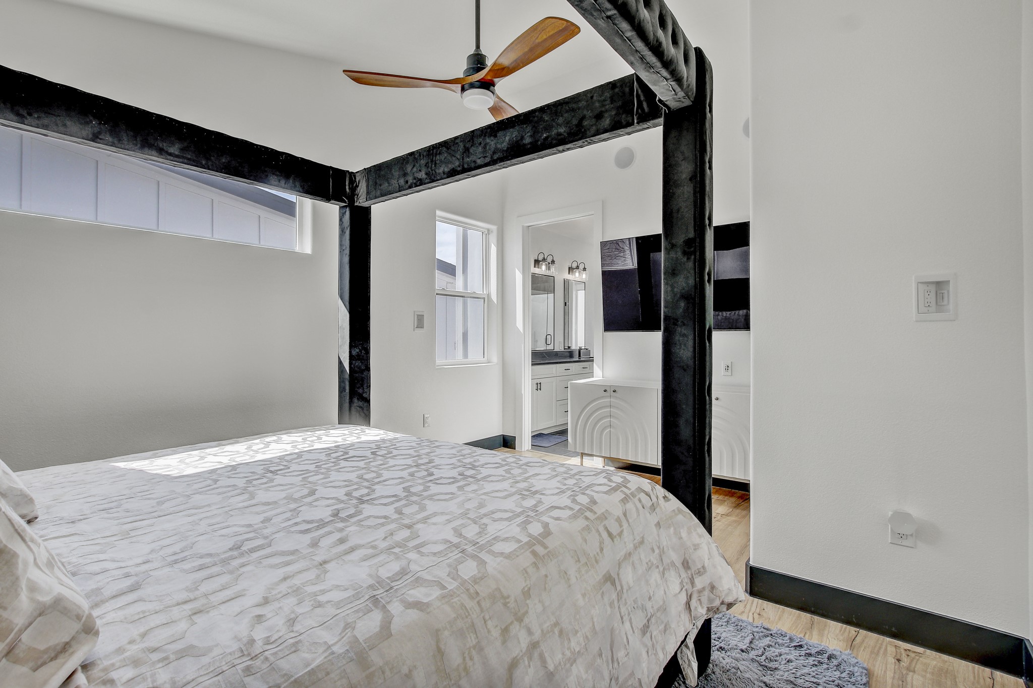 4703 Louis Avenue, Unit A Austin, TX 78721 - Photo 20 of 35 Bedroom featuring ceiling fan, light wood-style flooring, and ensuite bath