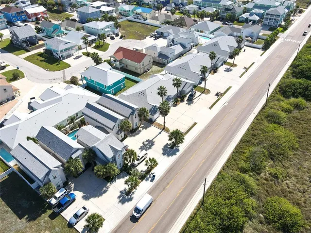 an aerial view of a residential houses with yard