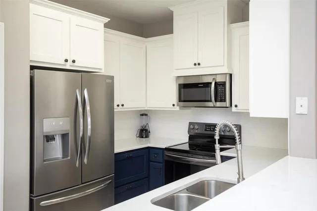 a kitchen with granite countertop a refrigerator stove and microwave