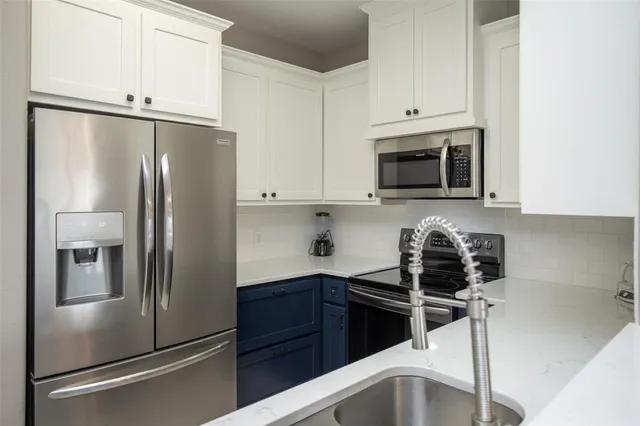 a kitchen with stainless steel appliances granite countertop a refrigerator sink and stove