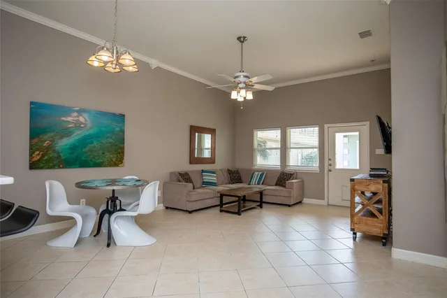 a living room with furniture a chandelier and a flat screen tv