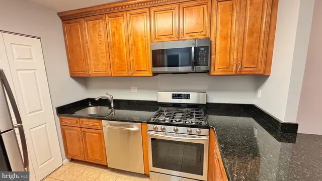 a kitchen with granite countertop wood cabinets and a stove top oven