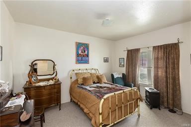 14433 Roy Rogers Ranch Road Oro Grande, CA 92368 - Photo 17 of 64 a bedroom with a bed and a painting on the wall