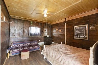 14433 Roy Rogers Ranch Road Oro Grande, CA 92368 - Photo 41 of 64 a bedroom with a bed and wooden floor