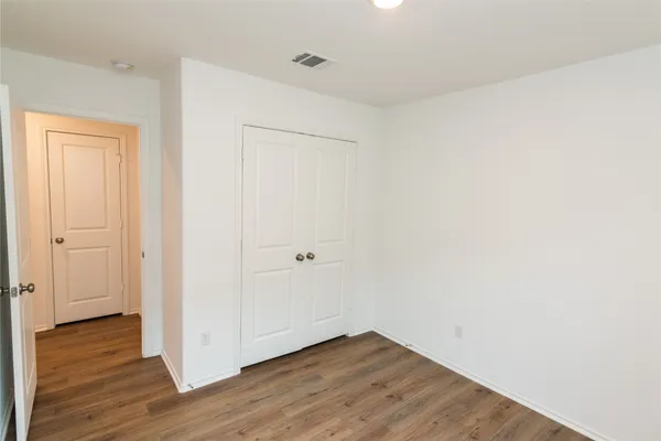 a view of an empty room with wooden floor