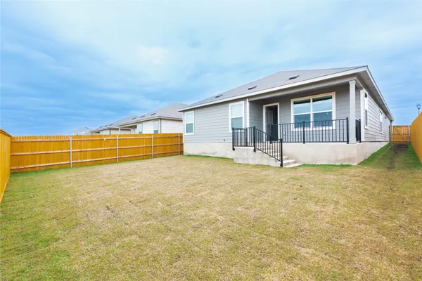 a view of an house with backyard space and balcony