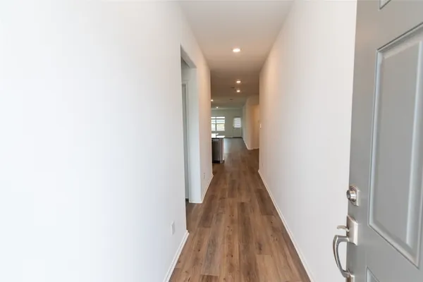 a view of a hallway with wooden floor and staircase