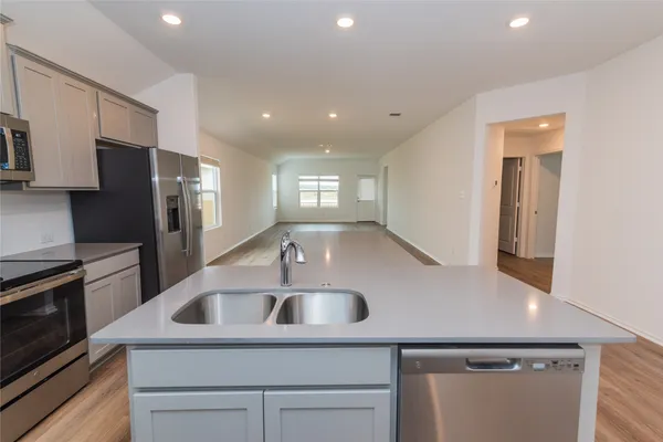 a kitchen with kitchen island a sink stainless steel appliances and cabinets