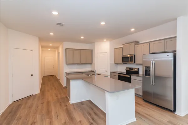 a kitchen with stainless steel appliances a refrigerator sink and microwave
