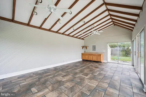 a view of a livingroom with wooden floor and a ceiling fan