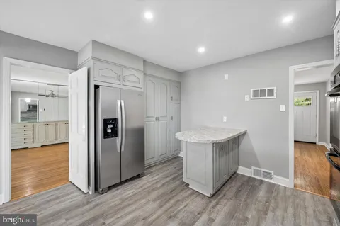 a view of a kitchen with refrigerator and wooden floor