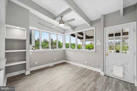 an empty room with wooden floor and windows