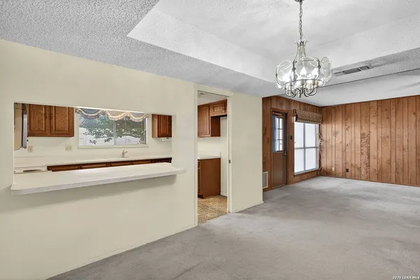 a view of an empty room with window and cabinet