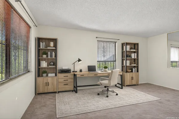 a view of a workspace with furniture and a window