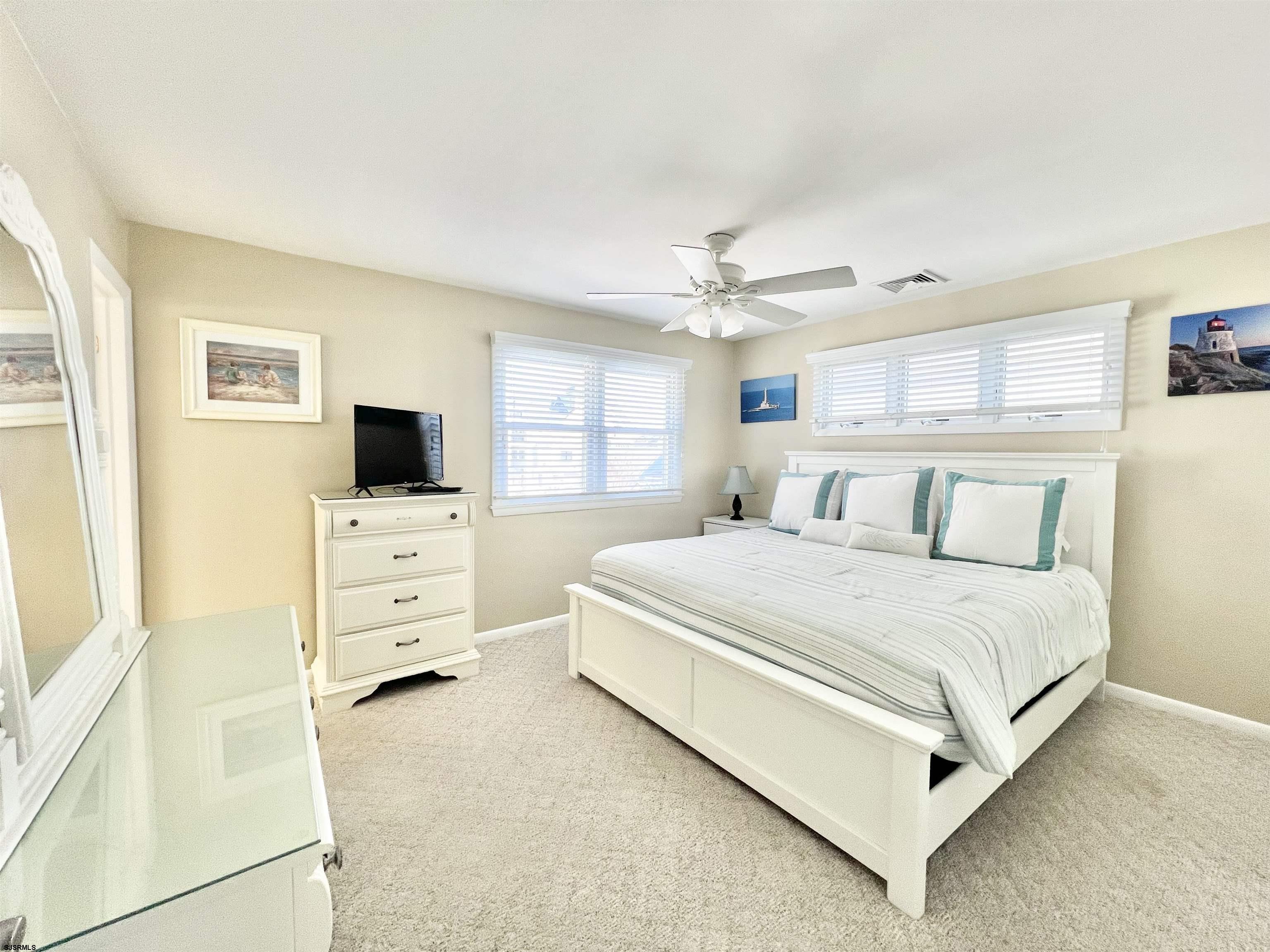 3 Simpson Road, Unit 2 Ocean City, NJ 08226 - Photo 16 of 23 a bedroom with a bed and flat tv screen on the dresser