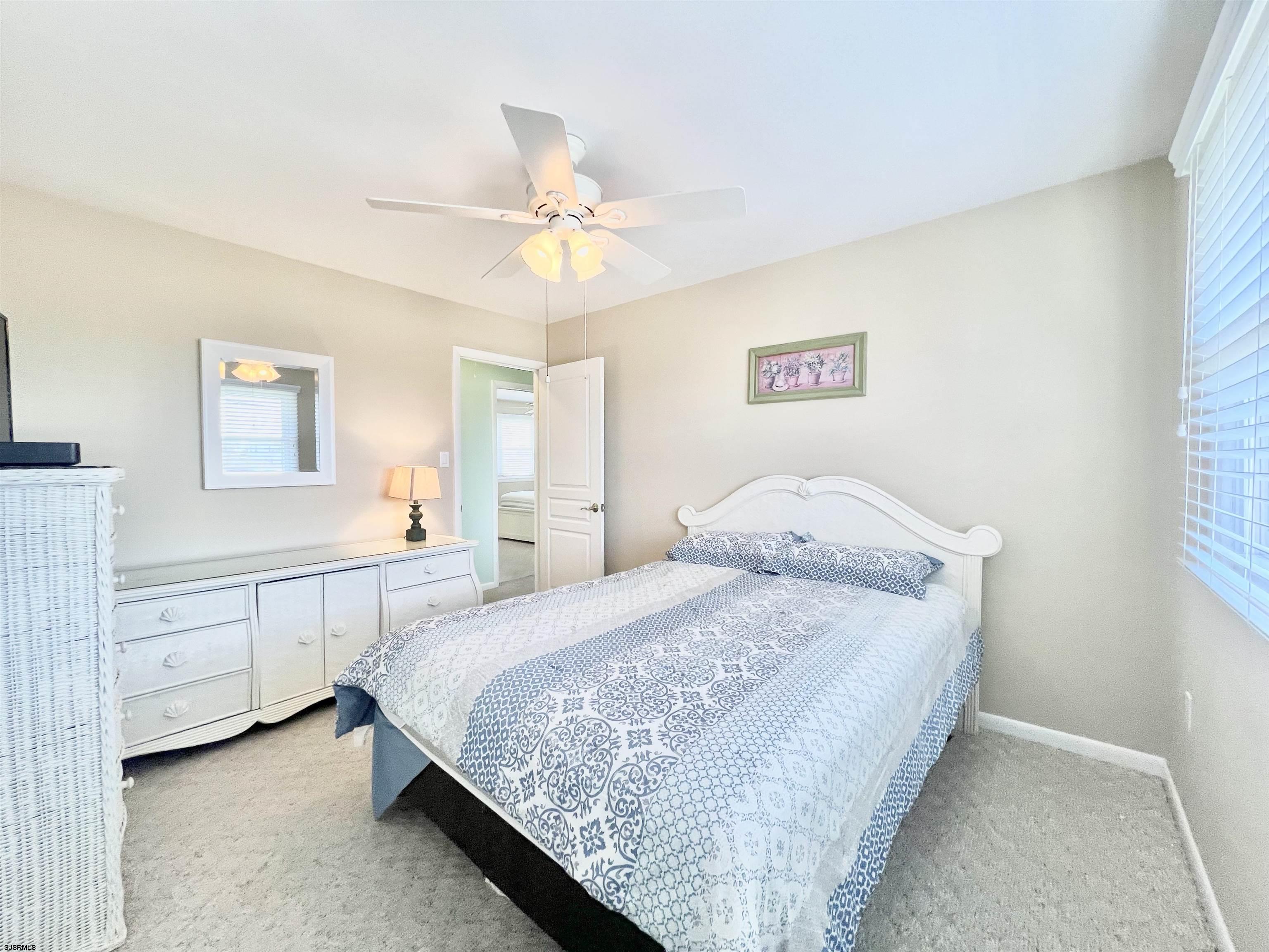 3 Simpson Road, Unit 2 Ocean City, NJ 08226 - Photo 20 of 23 a bedroom with a bed and a chandelier