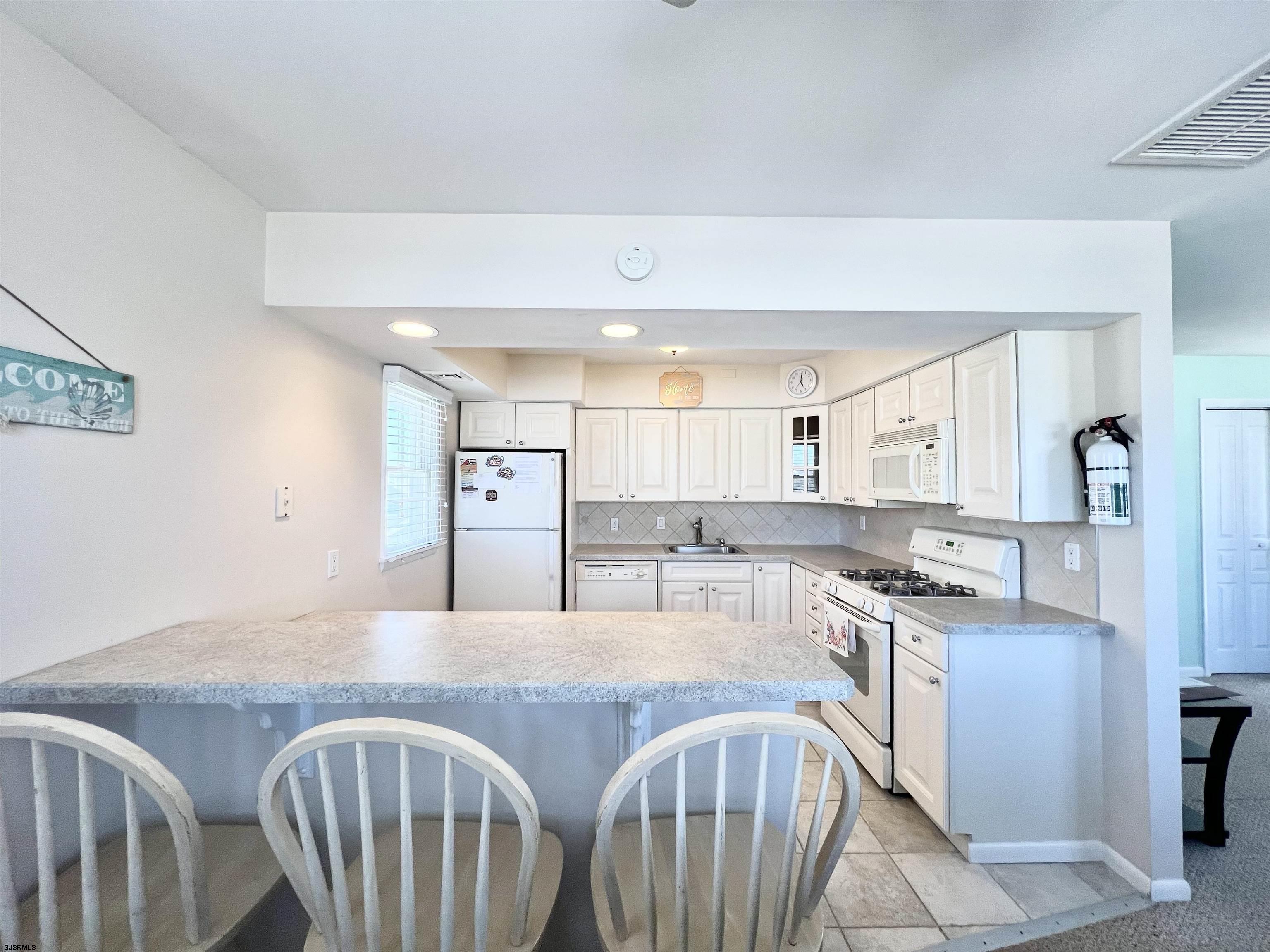 3 Simpson Road, Unit 2 Ocean City, NJ 08226 - Photo 7 of 23 a kitchen with stainless steel appliances granite countertop a stove a sink dishwasher and cabinets with wooden floor