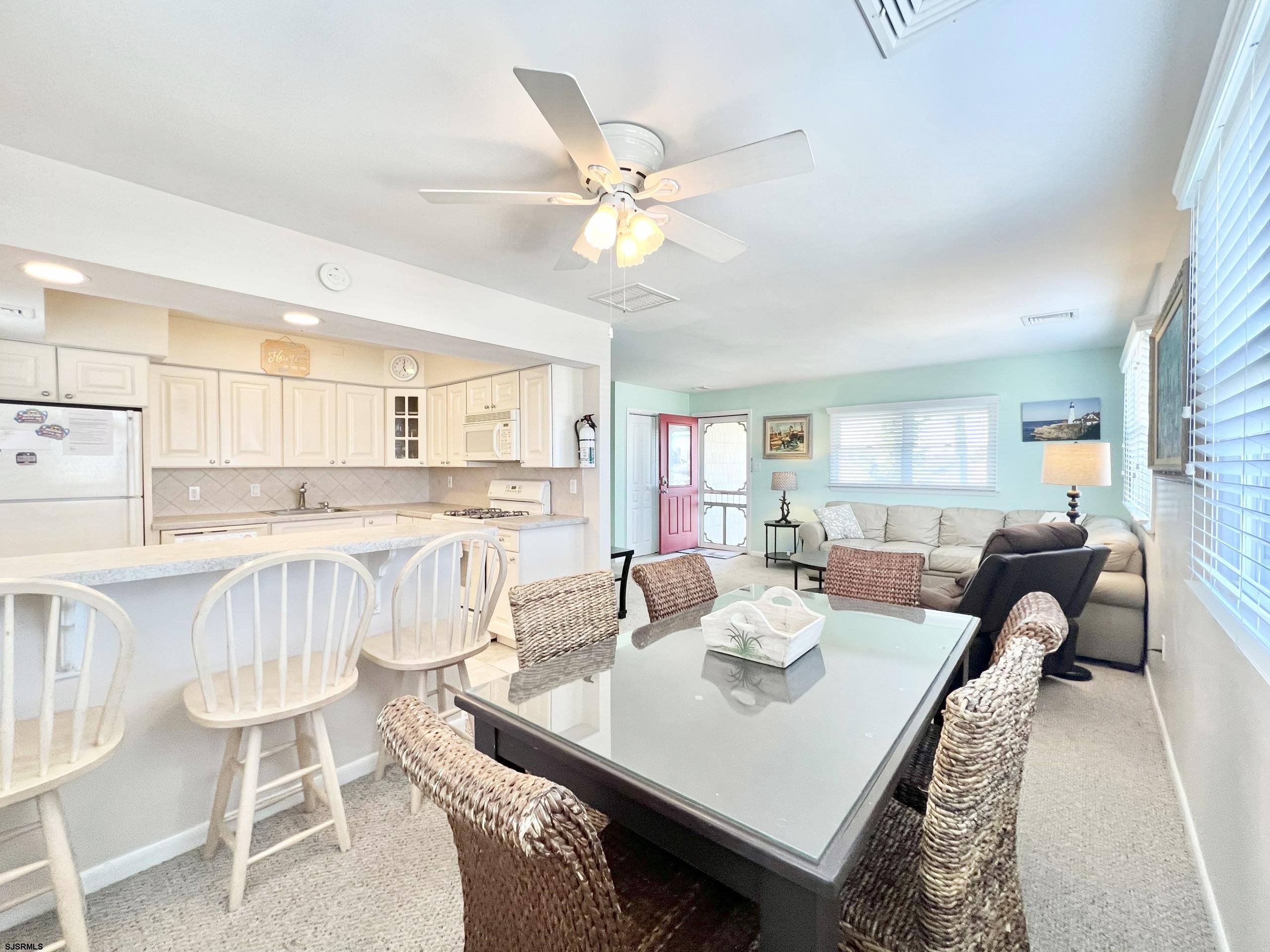 3 Simpson Road, Unit 2 Ocean City, NJ 08226 - Photo 9 of 23 a living room with kitchen island furniture and a chandelier