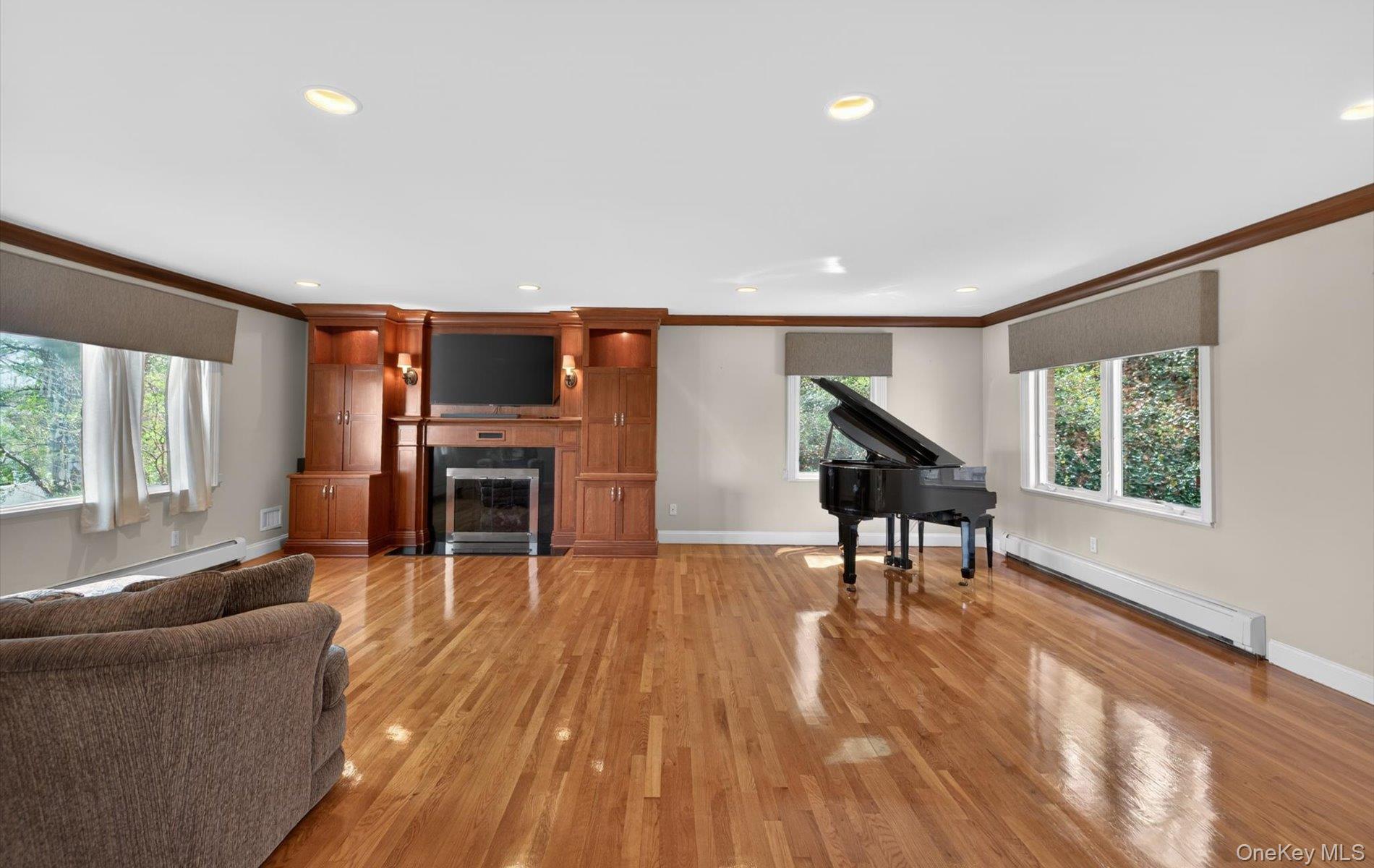 16 East Slope Road Bayville, NY 11709 - Photo 19 of 48 Hardwood flooring highlights this spacious interior featuring a built-in media center with integrated fireplace, recessed lighting, and multiple windows