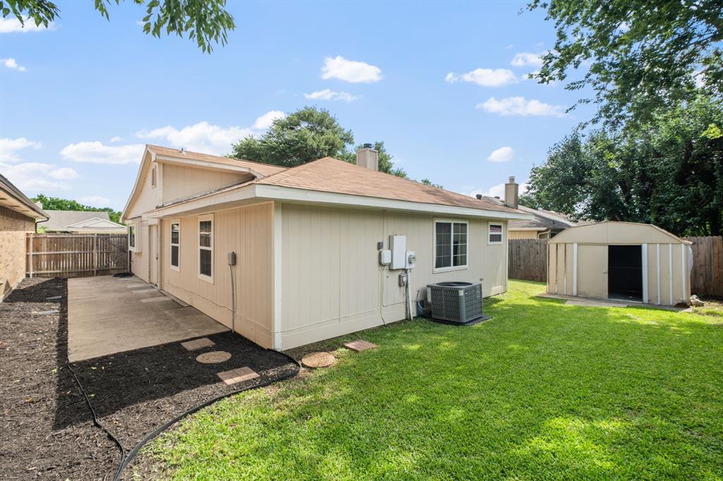 310 Valley Spring Drive Arlington, TX 76018 - Photo 23 of 24 Expansive backyard featuring a concrete patio, stepping stones, and a large storage shed
