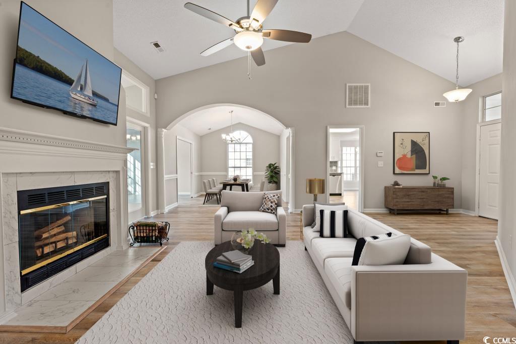 1639 Coventry Road Surfside Beach, SC 29575 - Photo 14 of 38 Living room with high vaulted ceiling, ceiling fan with notable chandelier, a fireplace, and light hardwood / wood-style floors