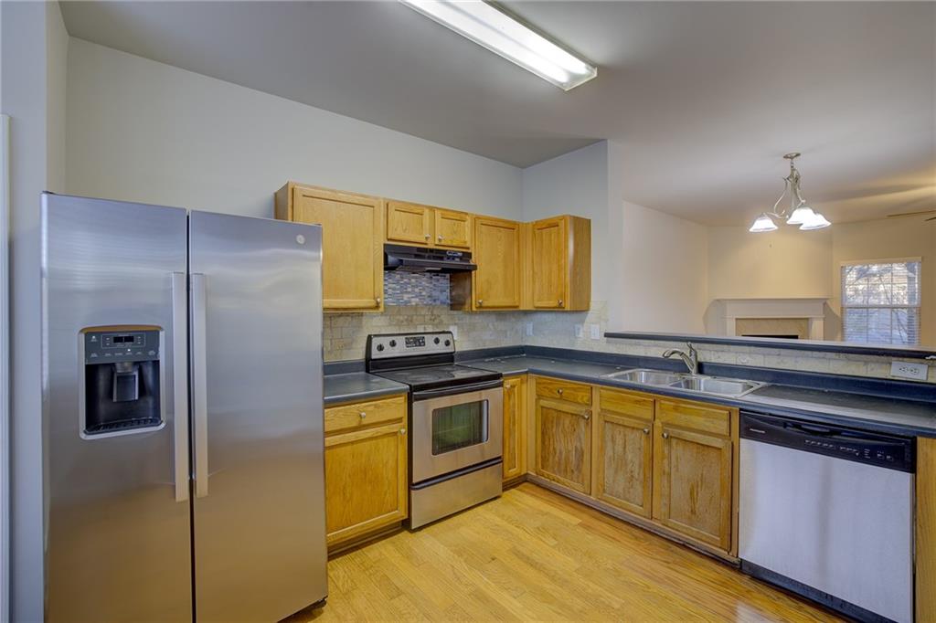 2161 Meadow Peak Road Duluth, GA 30097 - Photo 11 of 25 a kitchen with stainless steel appliances granite countertop a refrigerator a sink a stove and island